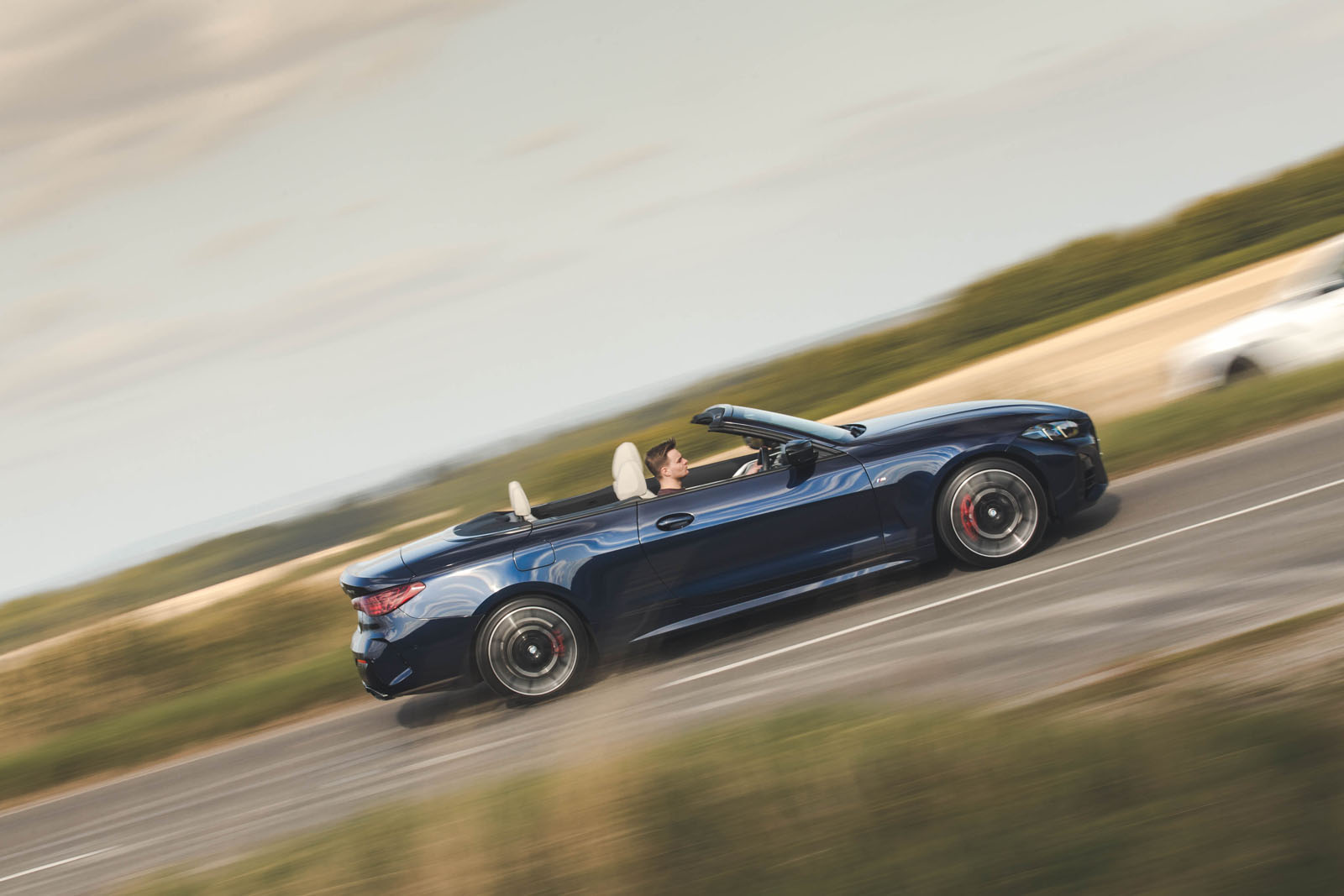 BMW M440i Cabriolet in blue   driving past, side profile