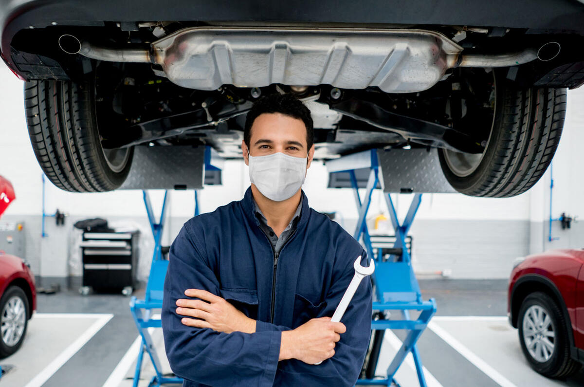 Mechanic under car with spanner